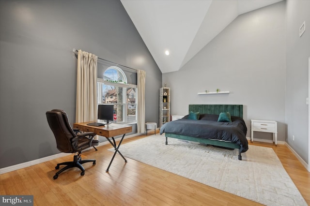 bedroom featuring high vaulted ceiling and wood-type flooring