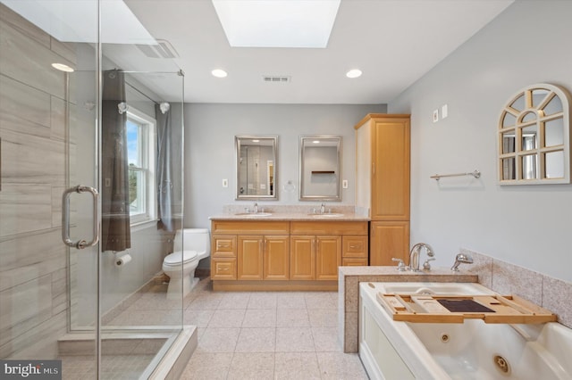 full bathroom featuring vanity, separate shower and tub, toilet, and a skylight