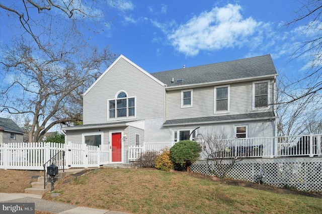 view of front facade featuring a front yard and a wooden deck