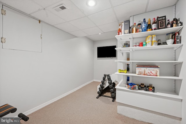 exercise room with a paneled ceiling and carpet floors