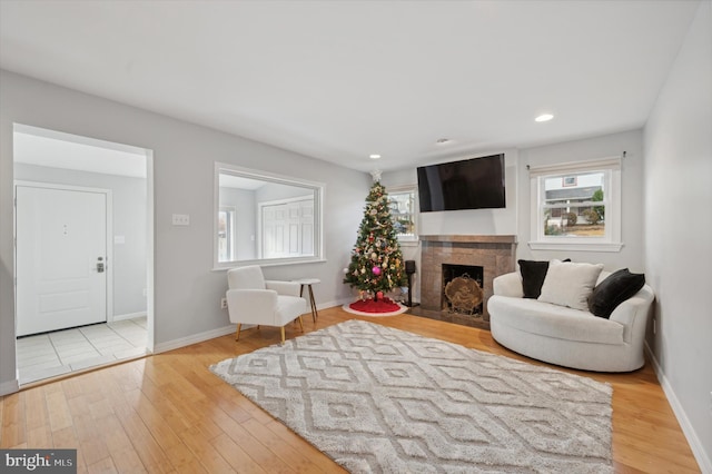 living room featuring light hardwood / wood-style floors and a tiled fireplace