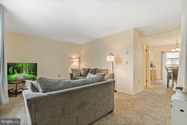 living room featuring a notable chandelier and light colored carpet