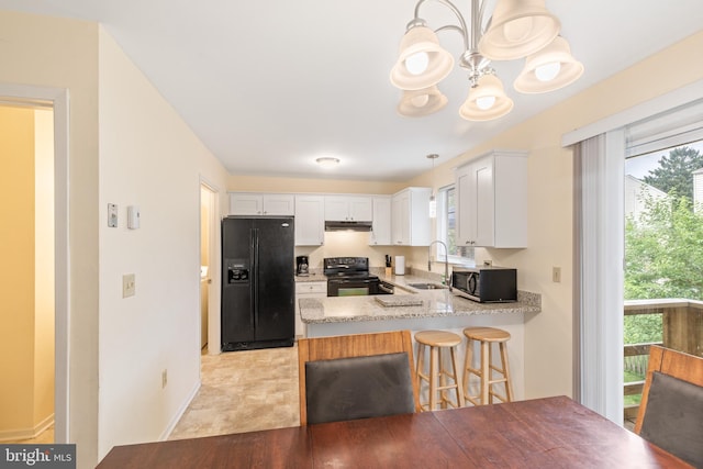 kitchen featuring pendant lighting, black appliances, sink, white cabinetry, and kitchen peninsula