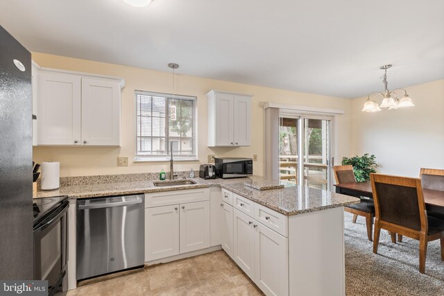 276 Broad St, Highspire, PA 17034 - kitchen featuring appliances with stainless steel finishes, a sink, white cabinets, a peninsula, and hanging light fixtures