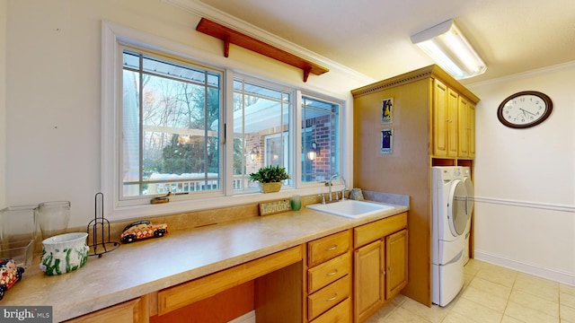 washroom featuring cabinets, ornamental molding, washer and clothes dryer, sink, and light tile patterned floors