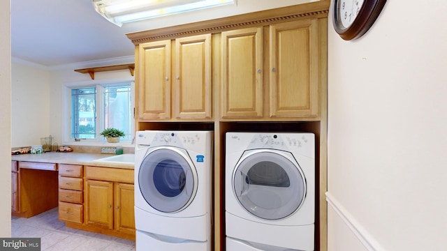 clothes washing area with cabinets, light tile patterned floors, washing machine and dryer, and crown molding