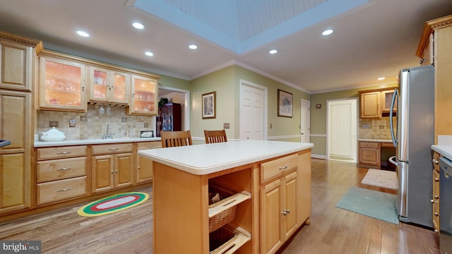 kitchen featuring stainless steel refrigerator, a center island, tasteful backsplash, light hardwood / wood-style flooring, and crown molding