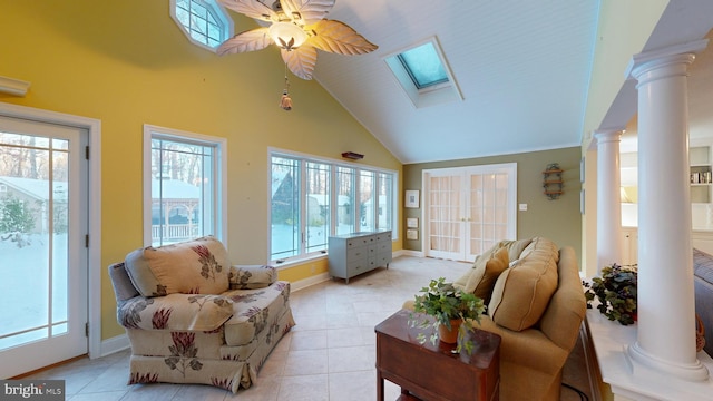 sunroom with ornate columns, lofted ceiling with skylight, a wealth of natural light, and ceiling fan