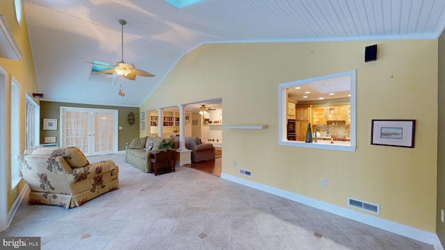 living room featuring ceiling fan, french doors, sink, built in features, and crown molding