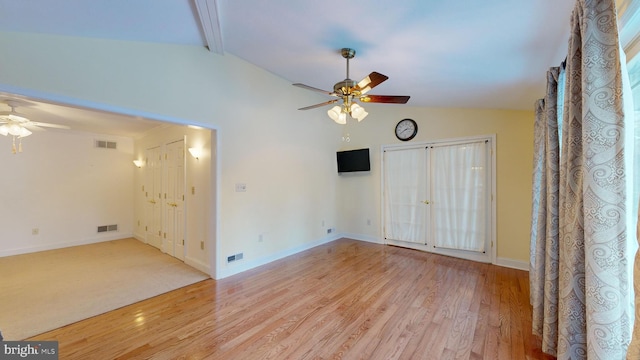 unfurnished room featuring vaulted ceiling with beams, ceiling fan, french doors, and light wood-type flooring