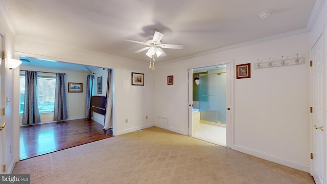 carpeted empty room featuring ceiling fan and crown molding