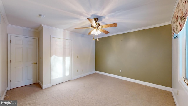 unfurnished bedroom with crown molding, ceiling fan, multiple windows, light colored carpet, and a closet