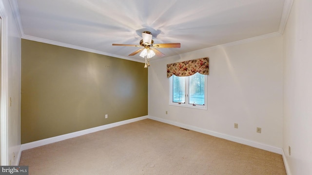 empty room featuring crown molding, ceiling fan, and light carpet