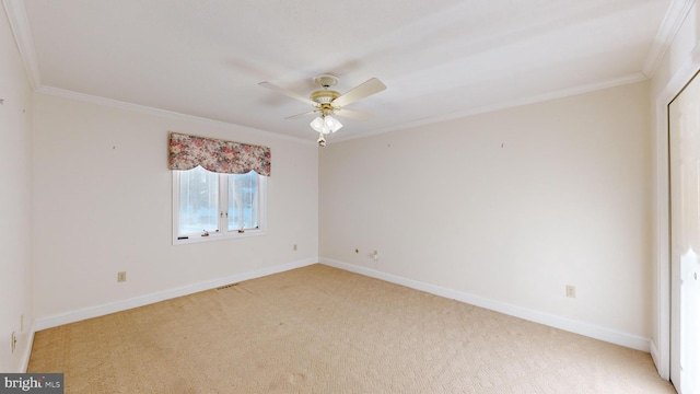 carpeted spare room with ceiling fan and ornamental molding