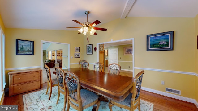 dining area featuring lofted ceiling with beams, ceiling fan, and light wood-type flooring