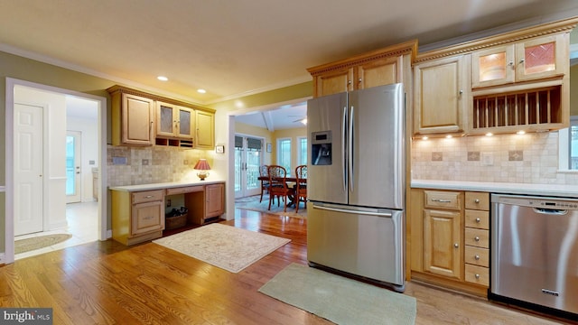 kitchen with crown molding, decorative backsplash, light hardwood / wood-style flooring, and stainless steel appliances