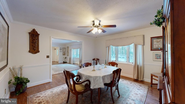 dining area with hardwood / wood-style flooring, ceiling fan, and ornamental molding