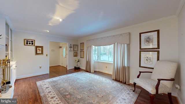 sitting room featuring wood-type flooring and ornamental molding