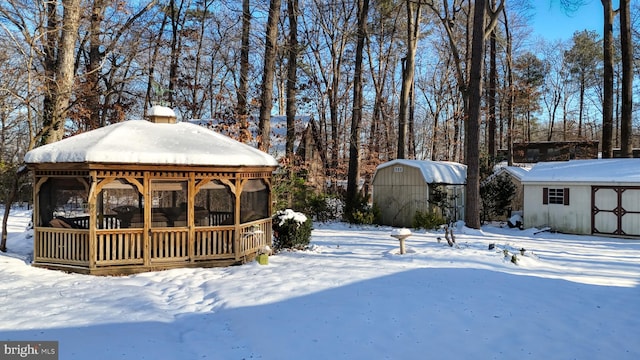 yard layered in snow featuring a shed