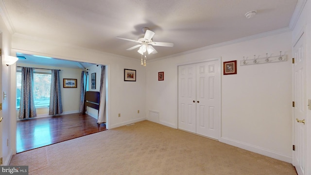 unfurnished room featuring crown molding, carpet, and ceiling fan