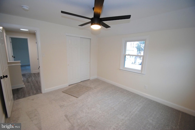 unfurnished bedroom with ceiling fan, light carpet, and a closet