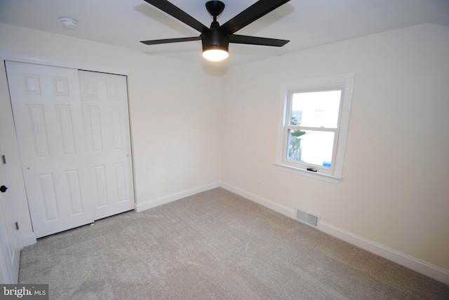 unfurnished bedroom featuring ceiling fan, light carpet, and a closet