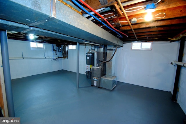 basement with heating unit, a healthy amount of sunlight, and water heater