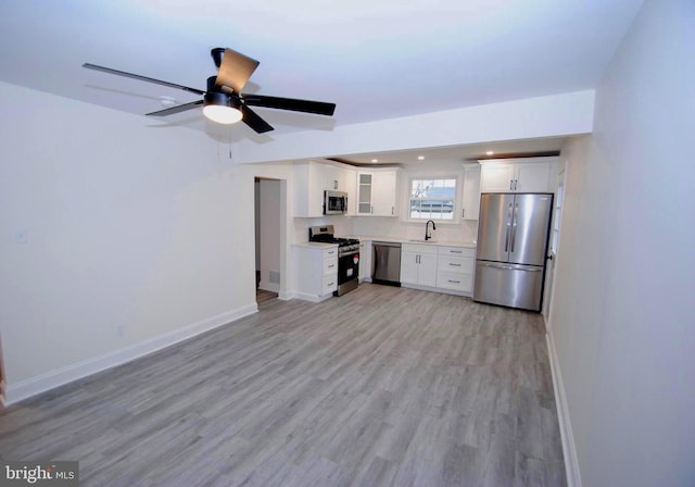 kitchen with light hardwood / wood-style flooring, white cabinets, stainless steel appliances, and sink