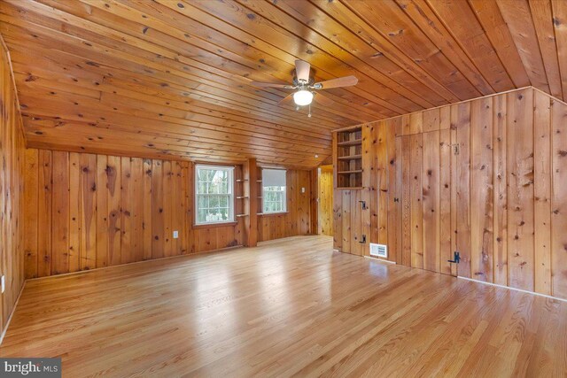 interior space with wood ceiling, vaulted ceiling, light hardwood / wood-style floors, and wood walls