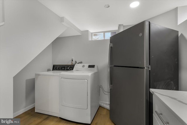 laundry area with washer / clothes dryer and light hardwood / wood-style floors