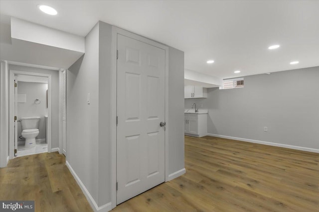 corridor with sink and light hardwood / wood-style flooring