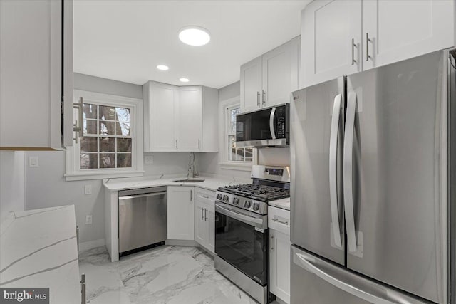 kitchen featuring light stone countertops, appliances with stainless steel finishes, sink, and white cabinets