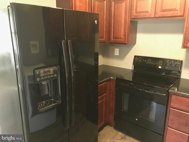 kitchen with light hardwood / wood-style flooring and black appliances