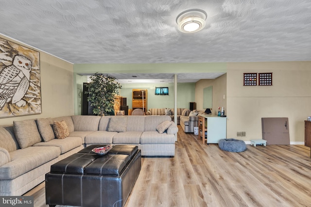 living room with light hardwood / wood-style floors and a textured ceiling