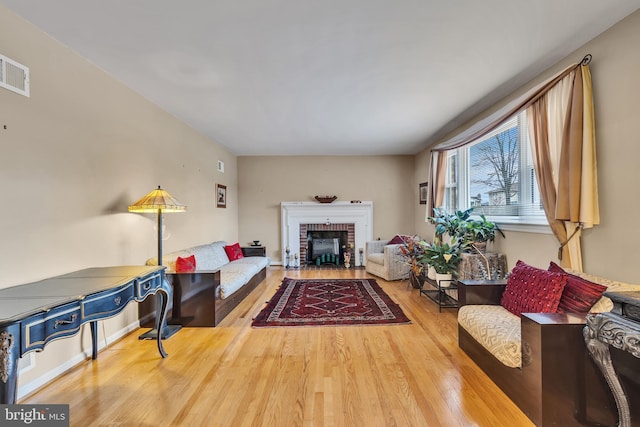 living room with a fireplace and wood-type flooring