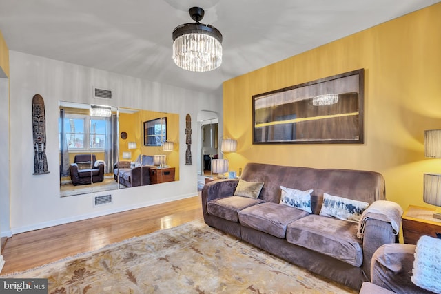 living room with hardwood / wood-style flooring and a notable chandelier