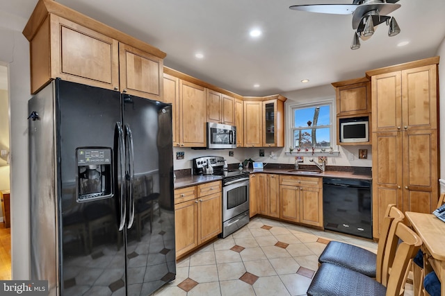 kitchen featuring light tile patterned flooring, sink, ceiling fan, and black appliances