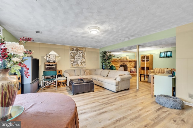 living room with a textured ceiling and light wood-type flooring