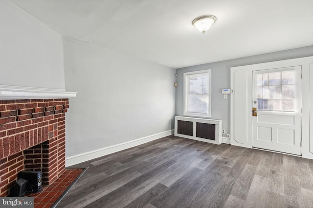 foyer entrance featuring a fireplace, dark wood-type flooring, and radiator