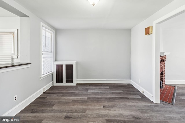 empty room featuring a fireplace and dark hardwood / wood-style floors