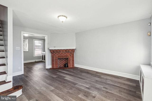 unfurnished living room with a fireplace and dark wood-type flooring