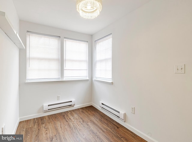 unfurnished room with a baseboard radiator, a notable chandelier, and wood-type flooring