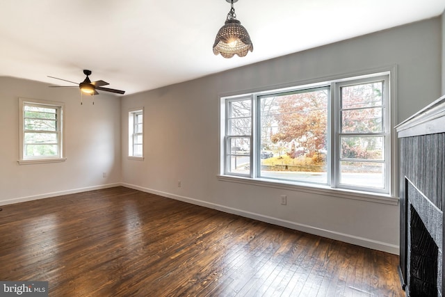 unfurnished living room with ceiling fan and dark hardwood / wood-style flooring