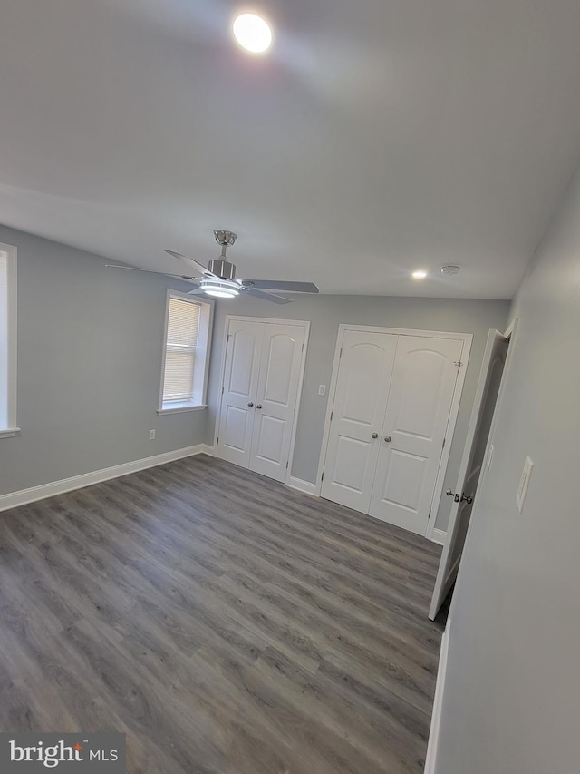 unfurnished bedroom featuring ceiling fan and dark wood-type flooring