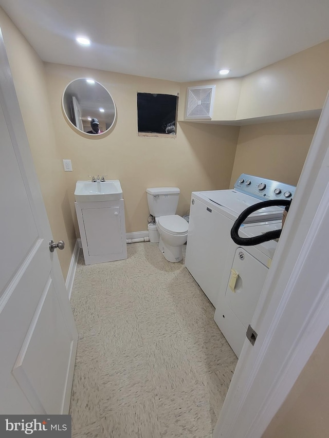 interior space featuring washer / clothes dryer, sink, and toilet