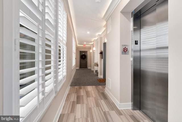 hallway featuring ornamental molding and elevator