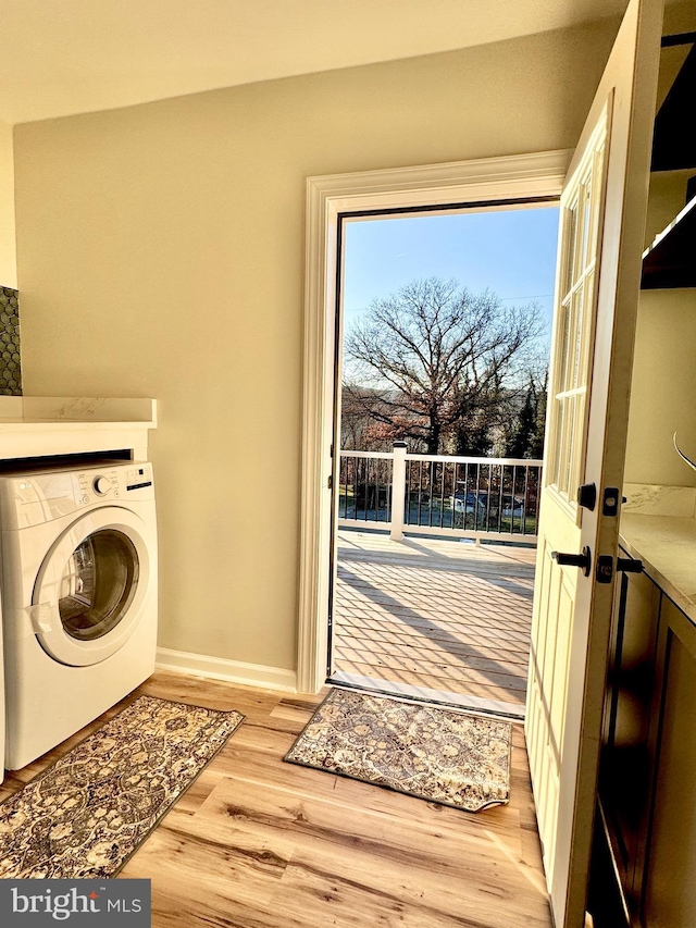 clothes washing area featuring washer / dryer and light wood-type flooring