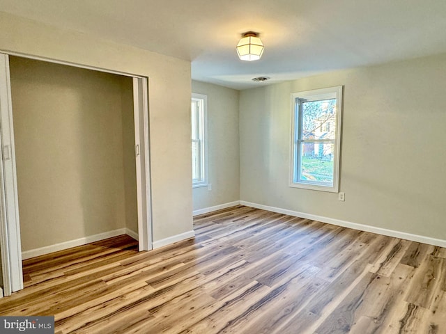 unfurnished bedroom with light hardwood / wood-style floors and a closet