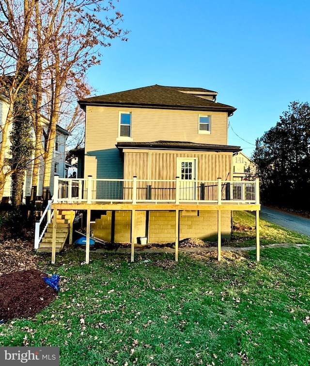 rear view of house with a deck and a yard