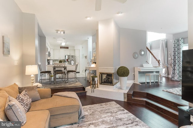 living room featuring a multi sided fireplace and dark hardwood / wood-style floors